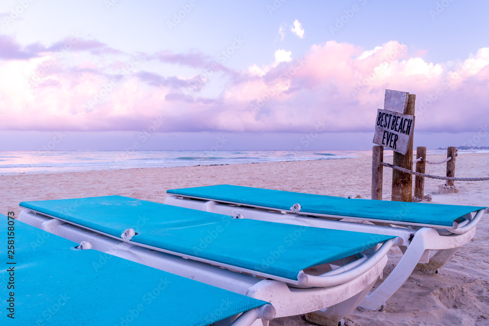 Empty beach chairs on tropical Caribbean island white sand beach