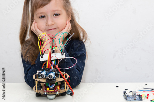 Wallpaper Mural A cute girl constructs metal robot and program it. The boards and microcontrollers are on the table. STEM education inscription. Programming. Mathematics. The science. Technologie. DIY.  Torontodigital.ca