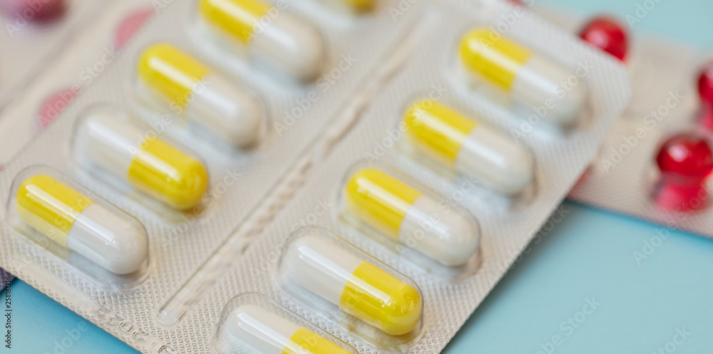 pharmaceuticals antibiotics pills medicine. Colorful antibacterials pills on blue background. Capsule pill medicine pharmaceuticals antibiotics pills medicine. Colorful antibacterials pills on blue background. Capsule pill medicine
