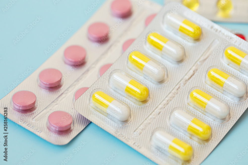 pharmaceuticals antibiotics pills medicine. Colorful antibacterials pills on blue background. Capsule pill medicine pharmaceuticals antibiotics pills medicine. Colorful antibacterials pills on blue background. Capsule pill medicine