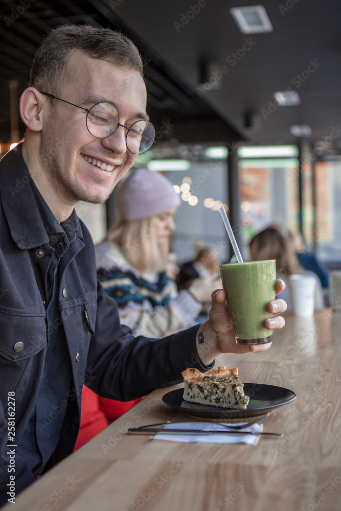 Handsome little bearded man holding fork eating in cafe and smiling looking at camera Handsome little bearded man holding fork eating in cafe and smiling looking at camera