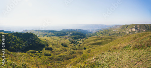 A large panorama of the hilly and mountainous area on a summer day.