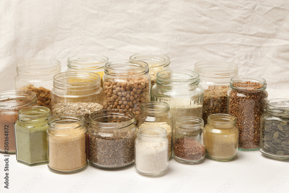 Many jars with grains, seeds, legumes, flours and various food ingredients. Healthy food concept. Many jars with grains, seeds, legumes, flours and various food ingredients. Healthy food concept.