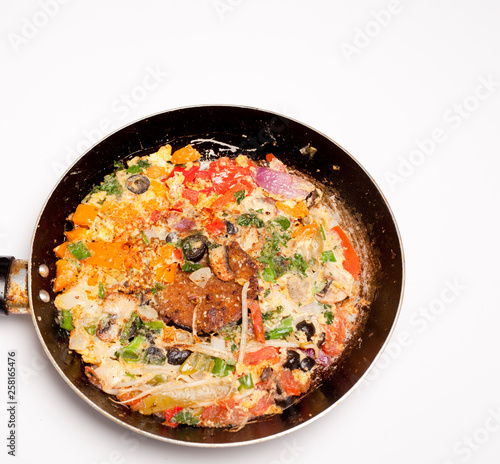 vegetable omelet in a black iron pan On a white background