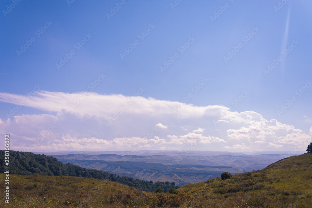 Obraz premium A huge panorama of the impending huge dark blue clouds over the mountains and hills in the summer