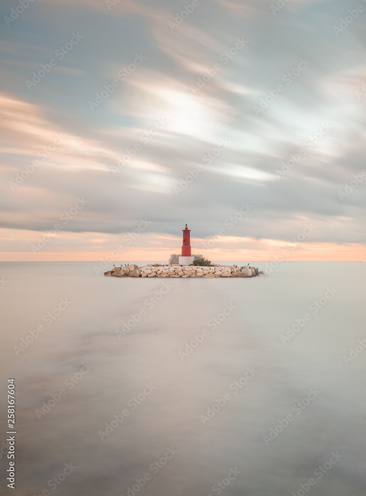 view of a lighthouse on a cloudy day in long exposure view of a lighthouse on a cloudy day in long exposure