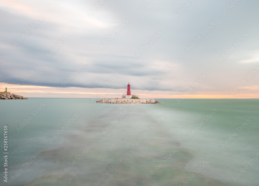 Fototapeta premium view of a lighthouse on a cloudy day in long exposure