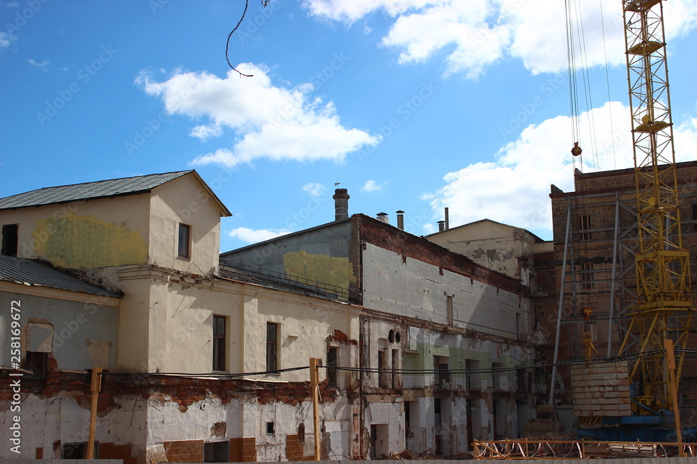 the destruction of the old building, reconstruction, structural changes. construction, high-rise crane works on the site. the building is made of brick, tiles on the walls. the destruction of the old building, reconstruction, structural changes. construction, high-rise crane works on the site. the building is made of brick, tiles on the walls.
