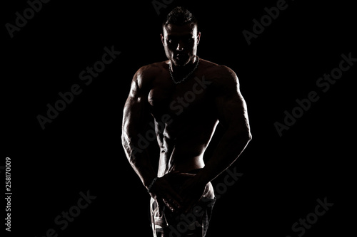 Bodybuilding competitions on the scene. Man sportsmen physique and athlete. Black background. © Mike Orlov