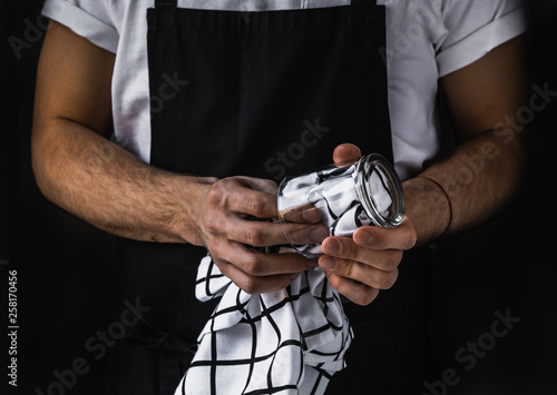 Waiter wiping clear glass. Restaurant staff. Service sector.