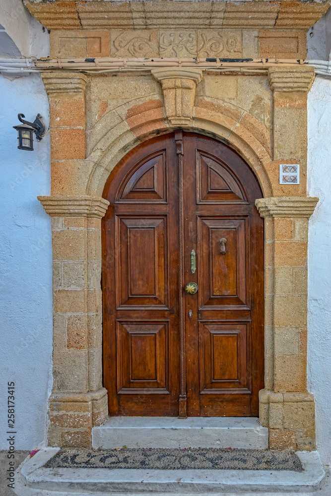 Wooden door in traditional Greek house in historic village of Lindos on Rhodes island. Greece.