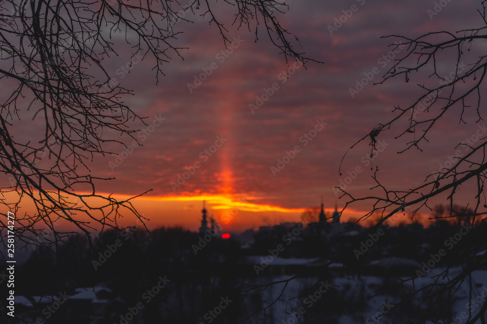 Obraz premium Light pole from the sun at sunset over the temple in Vladimir in winter