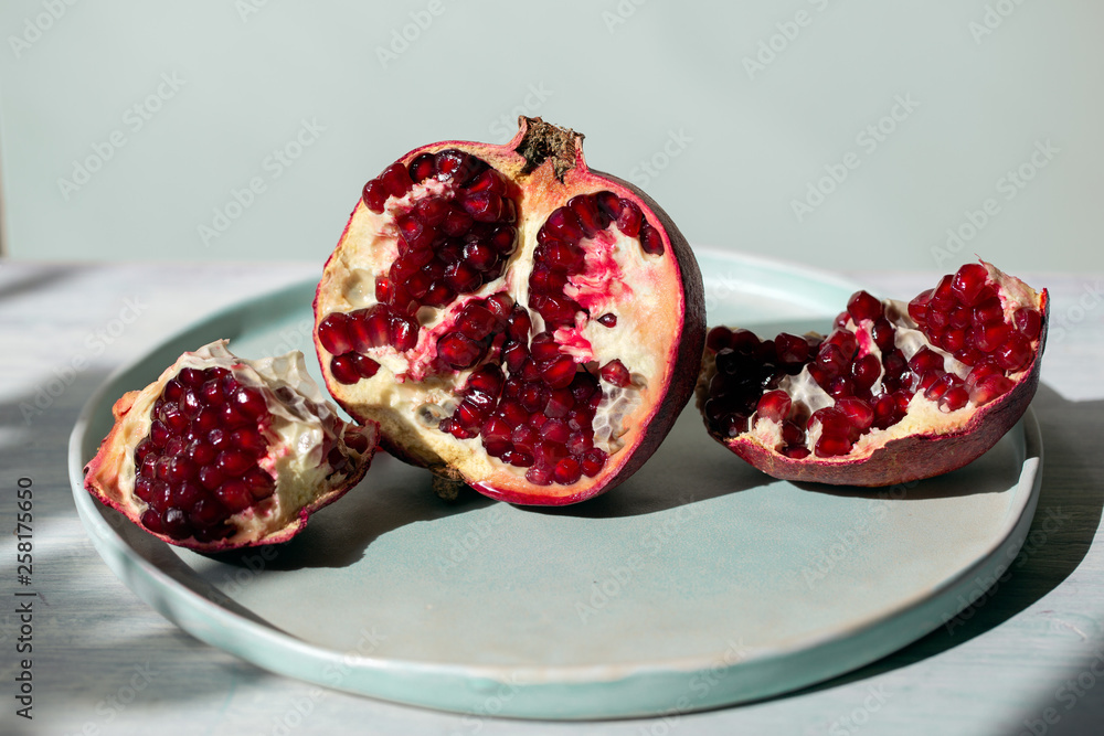 Ripe open pomegranate on blue background Ripe open pomegranate on blue background