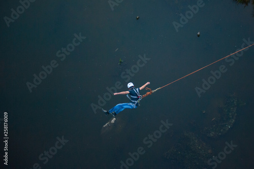 Extreme jump from the bridge. The man jumps surprisingly quickly in bungee jumping at Sky Park explores extreme fun. Bungee in the canyon.