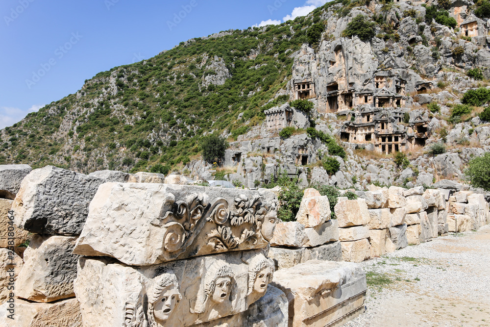 ancient, historic place, old tombs built in the mountains; in the foreground are rocks with raised reliefs on them, and a large mountain on the back ancient, historic place, old tombs built in the mountains; in the foreground are rocks with raised reliefs on them, and a large mountain on the back