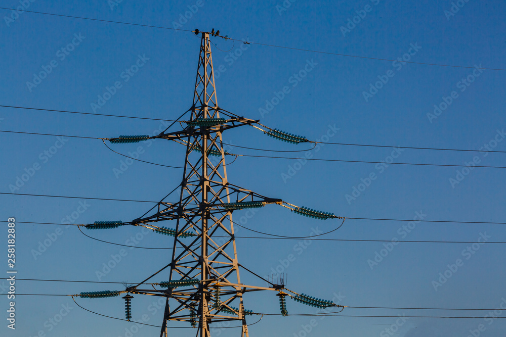 electricity transmission pylon silhouetted against blue sky at dusk electricity transmission pylon silhouetted against blue sky at dusk