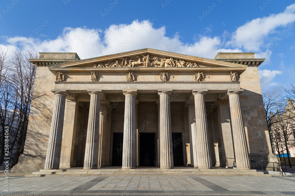 Obraz premium Neo-Classical facade of the Neue Wache, war memorial for the victims of war and dictatorship in Berlin, Germany, on a sunny day.
