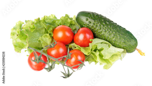 Fresh green cucumber, red tomatoes and green salad leaves isolated on white background. Ingredients for vegetable salad