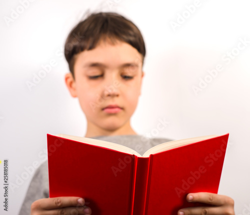Cute boy with book on white background
