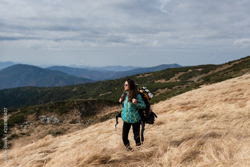 Fototapeta premium Hiking girl on a high green mountain.