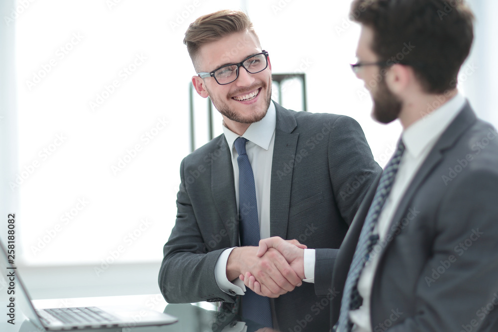 side view.handshake business partners sitting at the Desk side view.handshake business partners sitting at the Desk