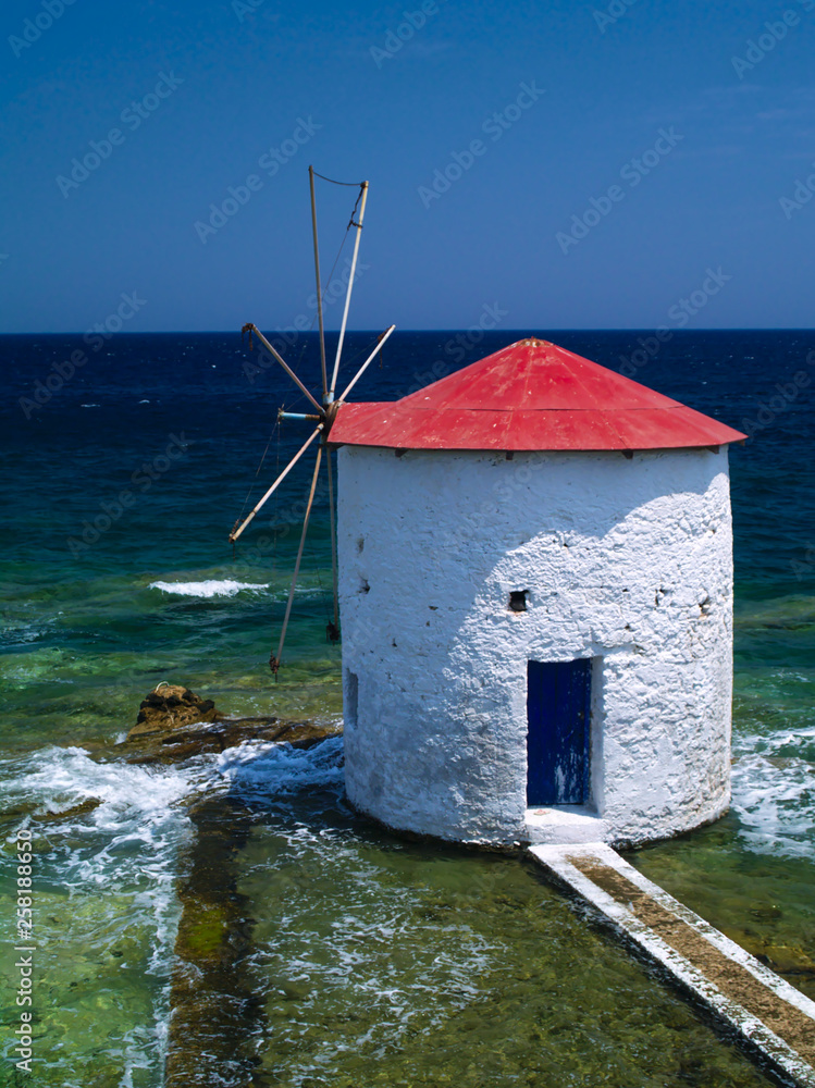 Traditional windmill in the sea. Landmark of Leros island, Greece.