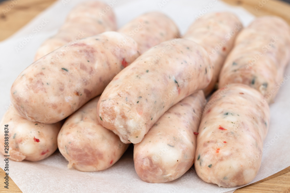 Fresh raw sausage on the wooden background