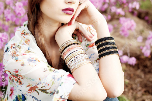 Outdoor high fashion portrait of young woman model, posing with trendy accessories and boho style clothes.
