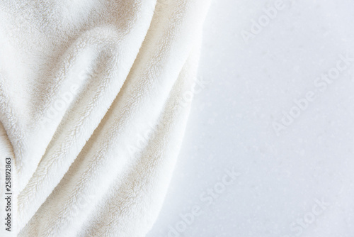 White delicate soft  background of plush fabric on white table. Copy space. 