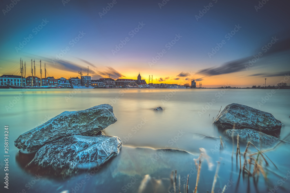 Atmospheric Sunset over the old medieval city of Kampen, nederland with its beautiful skyline - obrazy, fototapety, plakaty 