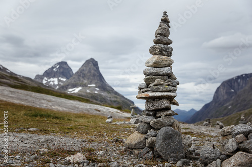 Manmade pyramide of small rocks with big mountain behind © Anastasia