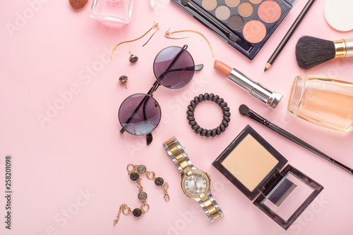Beauty concept in a blog. Professional female make-up accessories, watch, bracelet, lipstick, powder, on a pink background. Women's background and fashion. Instagram, women's things. Flat lay