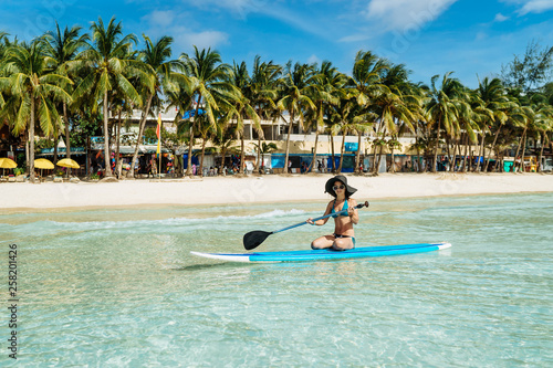 Woman is enjoying a view in standup paddleboarding over the ocean © matilda553