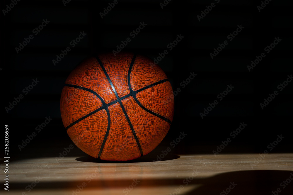 Obraz premium Basketball ball on the parquet with black background