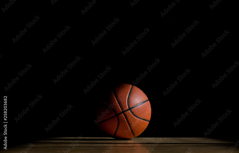 Obraz premium Basketball ball on the parquet with black background