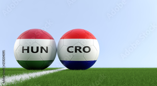 Hungary vs. Croatia Soccer Match - Soccer balls in Hungarys and Croatias national colors on a soccer field. Copy space on the right side - 3D Rendering  photo