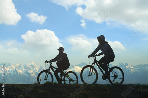 Two Cyclists Against Mountain Landscape