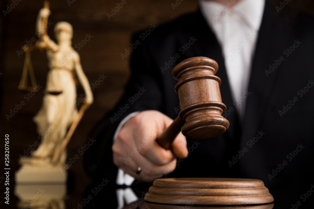 Judge, male judge in a courtroom striking the gavel Judge, male judge in a courtroom striking the gavel