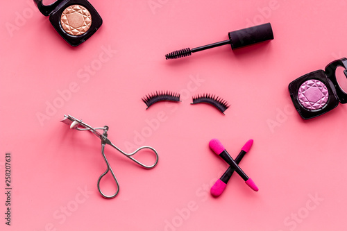 female desk with decorative cosmetic on pink background flatlay