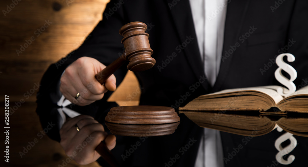 Judge, male judge in a courtroom striking the gavel Judge, male judge in a courtroom striking the gavel