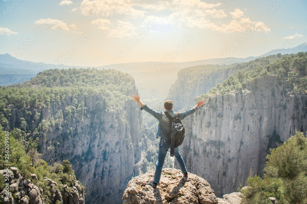 Obraz premium Young traveller enjoying a looking at sunset on Panoramic mountains view. Traveling, active lifestyle concept