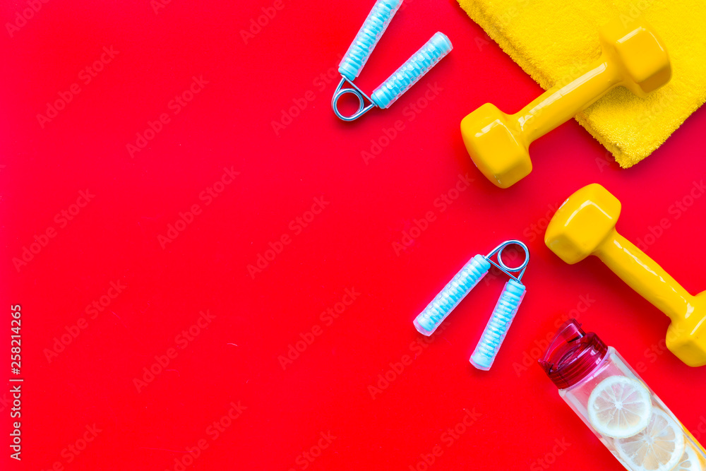 workout with bars, bottle of water and wrist builder red background top view mockup workout with bars, bottle of water and wrist builder red background top view mockup