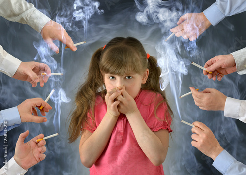 Smoking in front of the child kid .A little girl covers her nose from tobacco smoke.Conceptual photography.