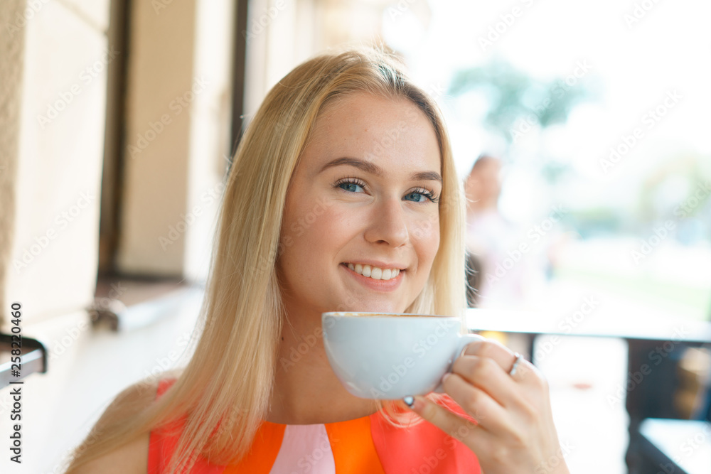 young beautiful blond woman sit at table in cafe drink coffee wait for businesspartner have a business meeting young beautiful blond woman sit at table in cafe drink coffee wait for businesspartner have a business meeting