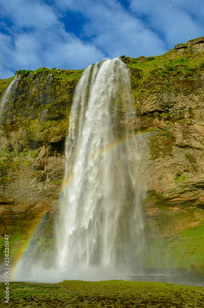 Close up profile view of iceland waterfall seljalandsfoss with rainbow Close up profile view of iceland waterfall seljalandsfoss with rainbow