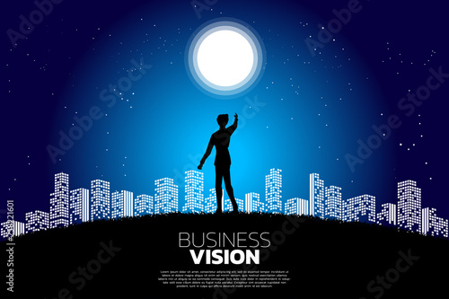silhouette of businessman point forward to the moon in the city night. Concept of growth business, Success in Career path.