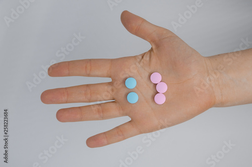 A hand with a smiling face made of pills