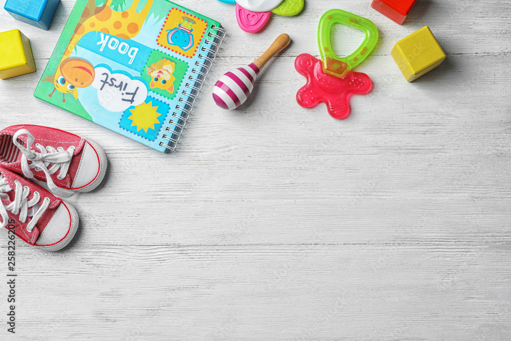 Flat lay composition with baby accessories and toys on light wooden background. Space for text Flat lay composition with baby accessories and toys on light wooden background. Space for text