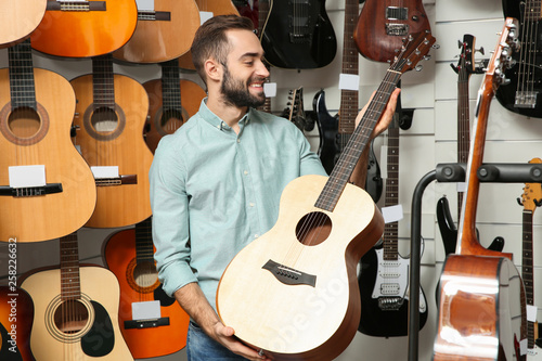 Buyer choosing guitar in modern music store