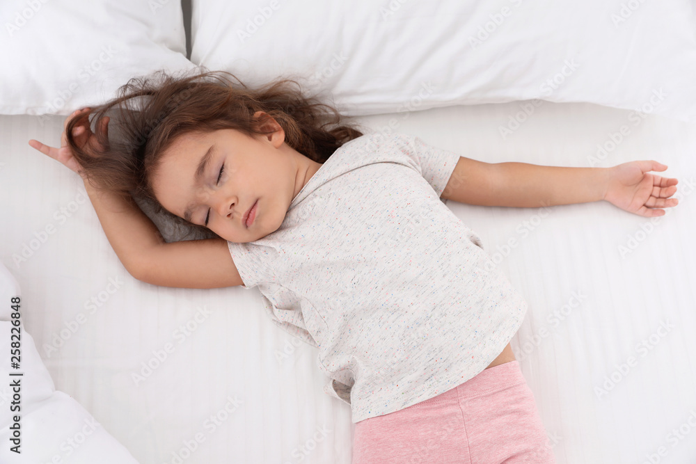Cute little girl sleeping on cozy bed, view from above Cute little girl sleeping on cozy bed, view from above